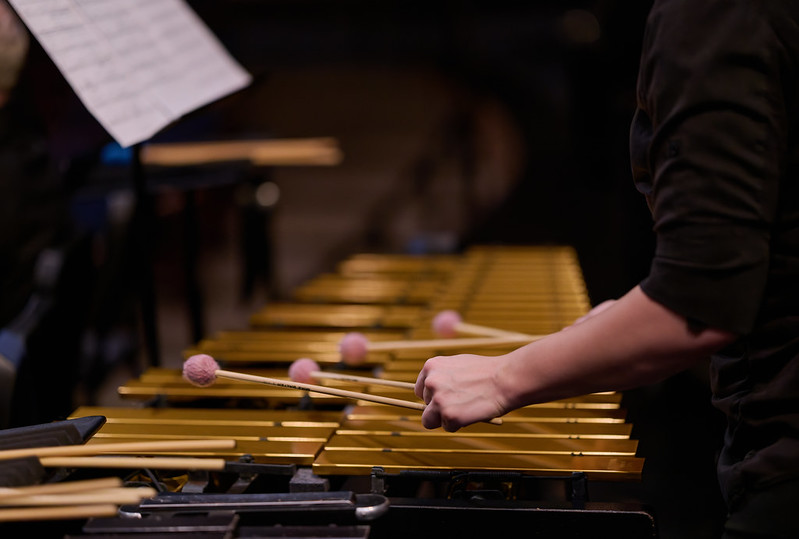 An closeup image of a musician playing mallets during a concert.